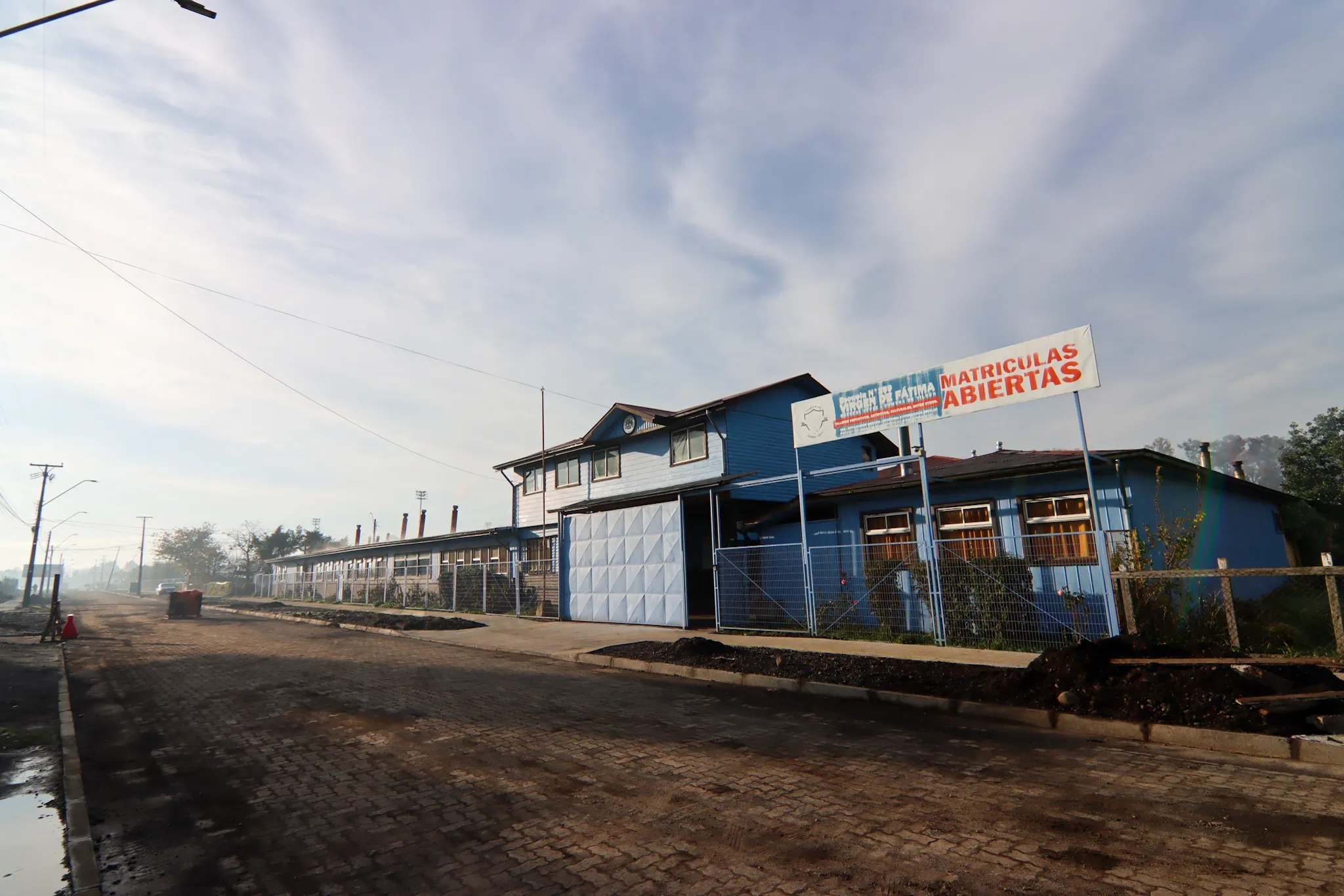 Fachada de la escuela con el letrero de matrículas abiertas